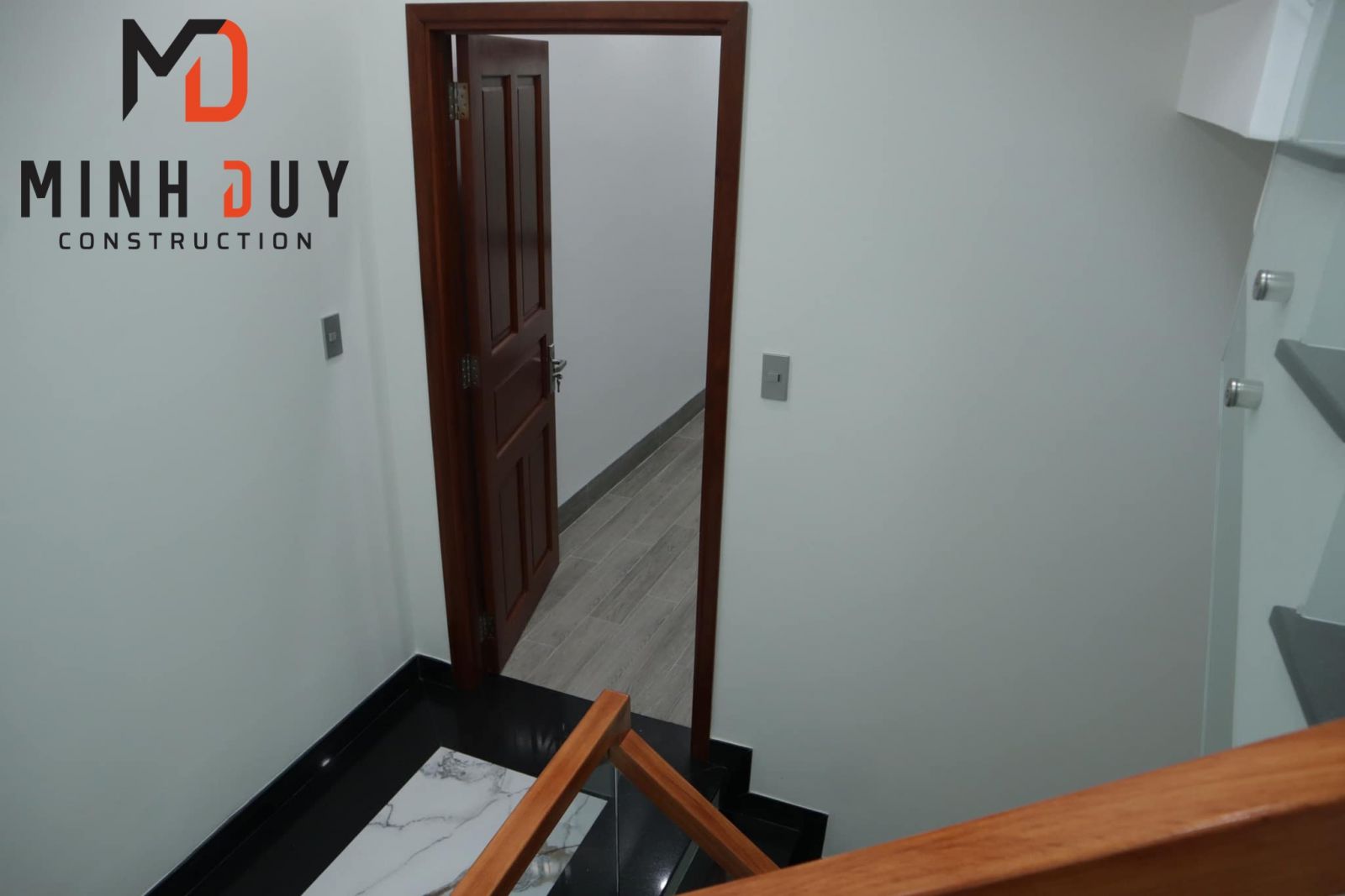 Hình ảnh Cầu thang kính cường lực, lan can gỗ dự án nhà phố tại TP.Thủ Đức sau khi hoàn thiện - Xây Dựng Minh Duy