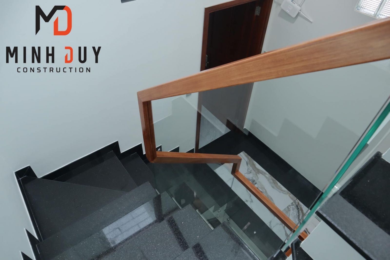 Hình ảnh Cầu thang kính cường lực, lan can gỗ dự án nhà phố tại TP.Thủ Đức sau khi hoàn thiện - Xây Dựng Minh Duy