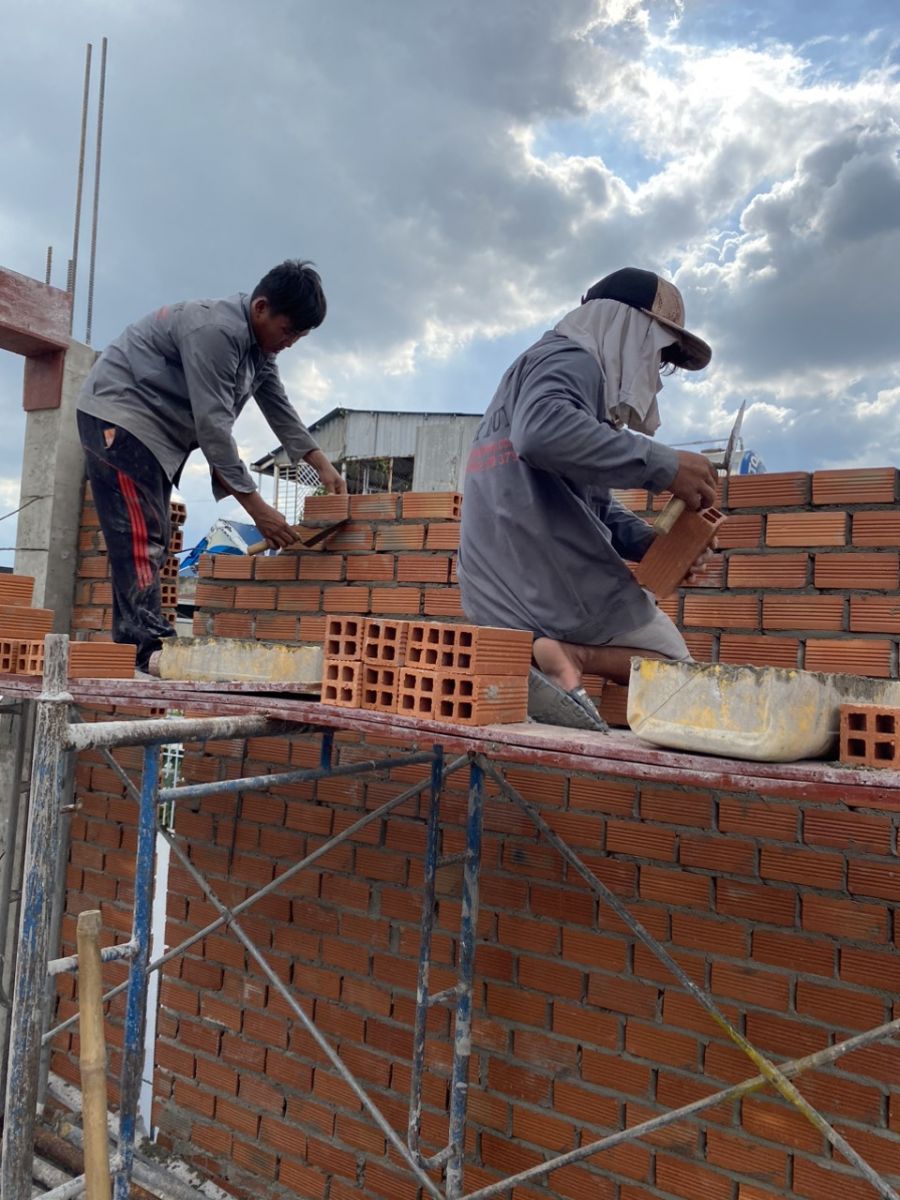Hình ảnh thợ đang xây tường bao hoặc tường ngăn trên các tầng
