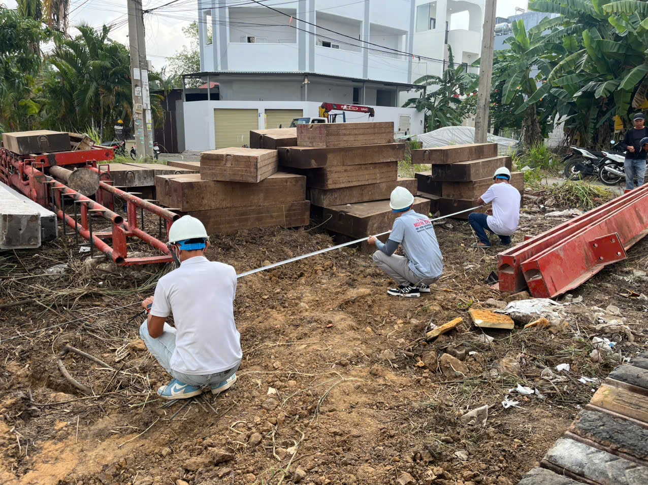 Hình ảnh Kỹ sư Xây Dựng Minh Duy đang cầm thước đo đạc đất xây dựng